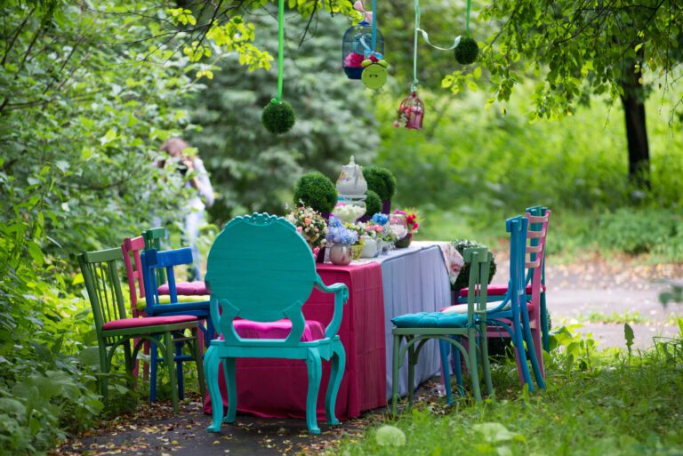 About us: a whimsical visual of an empty garden party table with mismatched chairs and tablecloths